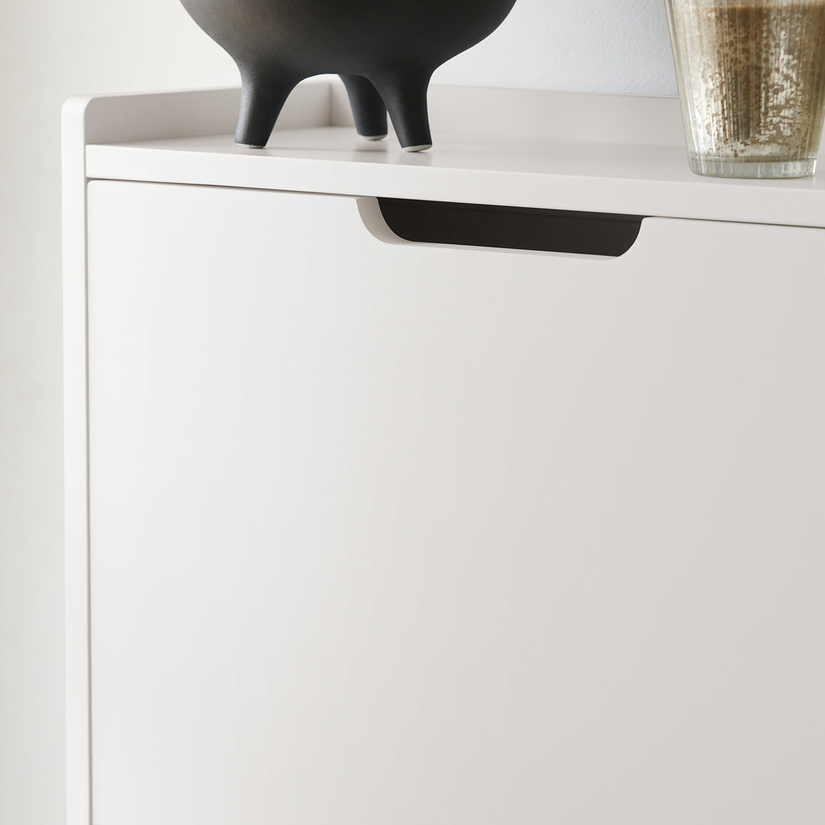 Hidden handle on cabinet door for a sleek look and space-saving design.