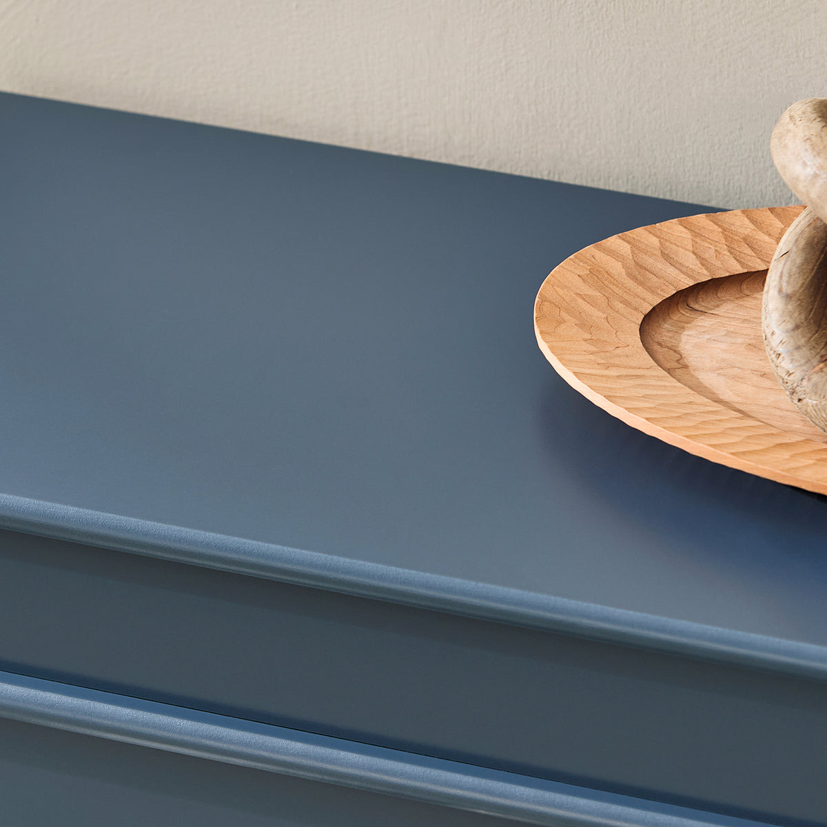 Top surface of blue shoe cabinet used as hallway display shelf