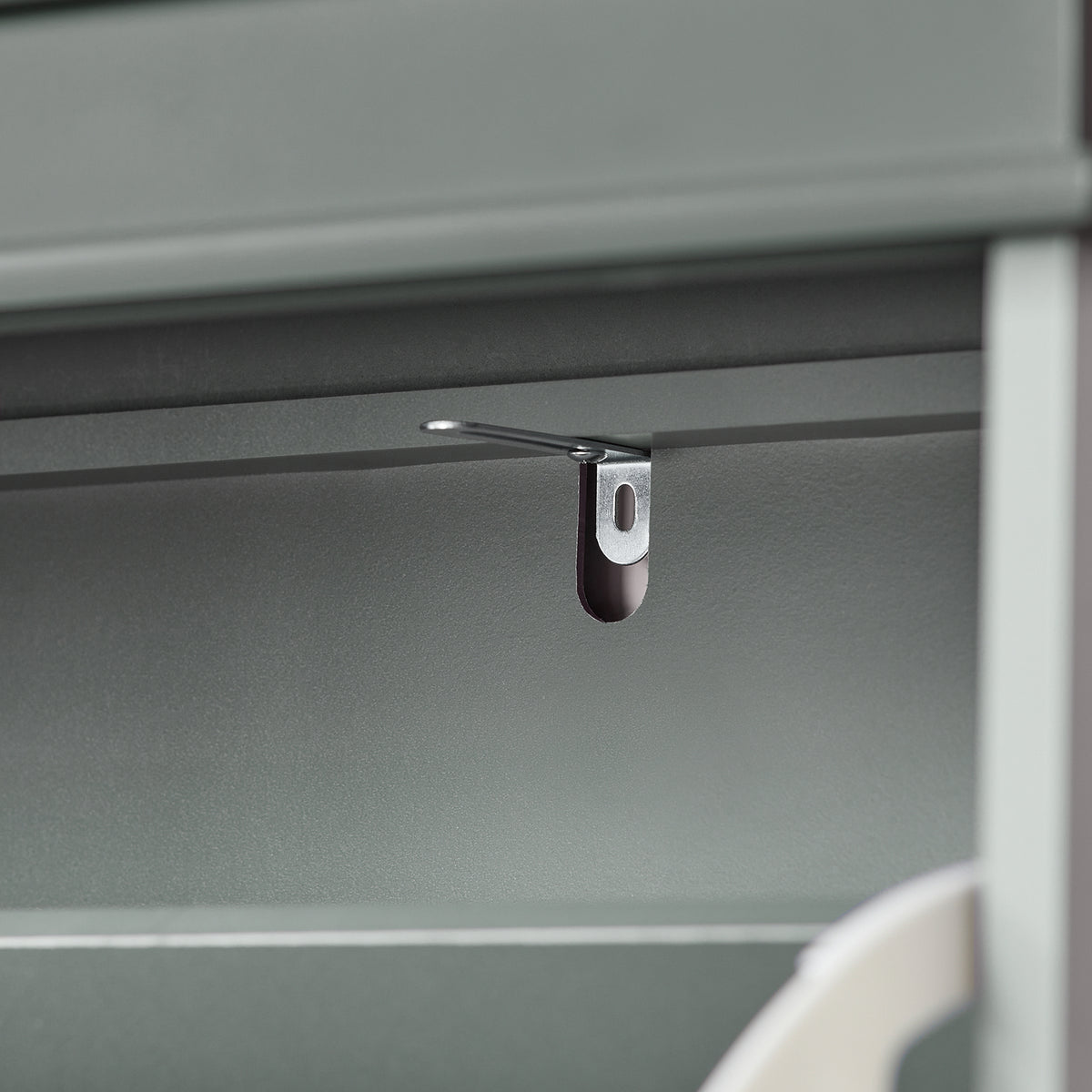 Anti-tip safety device on grey shoe storage unit.