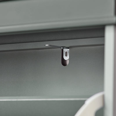 Anti-tip safety device on grey shoe storage unit.